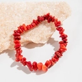 Bracelet en perles de corail rouge naturel irrégulier sur une pierre texturée blanche - Rouge