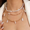 Détail du collier multicouche à chaîne trombone dorée et perles baroques sur blazer blanc - Style de Chaîne de Trombone en Perle Baroque à Trois Couches / Or (30347-nek-G-set)