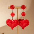 Detail view of long red heart earrings with beads hanging on a gold display stand - Red Round Bead Three-Tier Heart Drop Earrings (31486-ear-red-EP)
