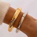 Detailopname van glanzende goud- en zilverkleurige gebogen buisarmbanden - Bamboe Metaal Goud Zilver Stijl (28469-GS)