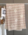 Detail of pink cashmere scarf with white rose print and tassels on a clothing hanger - Nude Pink