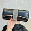 Elegant black evening clutch bag with sparkling rhinestone band and gold metal trim - Black