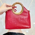 Elegant red woven handbag with a round golden metal handle and crossbody D-rings - Burgundy