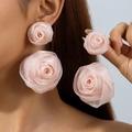 Gros plan de boucles d'oreilles rose en tissu avec double fleur et texture scintillante - Rose Rose en Maille à Double Couche / Rose Clair