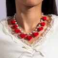 Close-up of pearl necklace with red velvet heart pendants on a female model - White Pearl Strand Flocked Red Heart Style (28637-red)