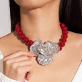 Macro view of vintage red acrylic beads with a large metallic silver flower pendant necklace - Red Round Beads Silver Flower Pendant(28852-red)