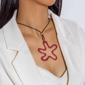Dettaglio di un ciondolo a stella rossa irregolare su una collana a cordoncino nero - Stile Stella Astratta Corda Lunga Rossa (28906-red)