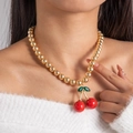 Detail of a cherry pendant necklace with red acrylic beads on a gold bead chain - Gold Bead Double Red Cherry (28914-G)
