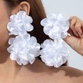 Grandi orecchini a fiore in raso bianco 3D indossati da una modella con stile - Bianco