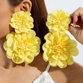 Orecchini a fiori in tessuto giallo vivace su modella con petali a strati vistosi - Giallo