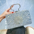 Pochette da sera argentata con strass, rilievo a pavone ed elegante manico in metallo - Argento