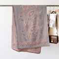 Detailed view of paisley pattern shawl with reversible blue and pink knit and tassels - Paisley Gray