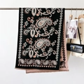Close-up of double-sided paisley shawl with fringe detail on a luxury display hanger - Paisley Black
