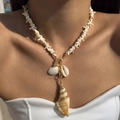 Detail of seashell and starfish pendant necklace with gold accents worn by a model - Starfish Beaded Conch Scallop OT Clasp Necklace (29073-white)