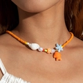 Detail of vibrant orange beaded necklace with starfish, seashell and small fish charms - Bright Orange (27625-orange)