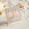 Dettaglio di orecchini a conchiglia sfumata rosa con ganci in argento su sabbia bianca - Stile Piccola Conchiglia a Ventaglio (29366-4)