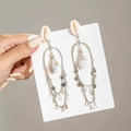 Dettaglio di orecchini bohémien con stelle marine, conchiglie e frange a cascata - Stile Bohemien con Nappa di Conchiglia (29406-S) / Conchiglia con Nappa Lunga Argento (29406-S)
