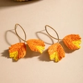 Detailed shot of leaf-shaped raffia earrings in orange and yellow gradient weave - Orange & Yellow Gradient Double Leaves (29363-orange)