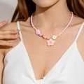 Close-up of pink beaded beach necklace with floral charms and pearls on a female model - Pink Flower Pendant (27625-nek-pink-5)