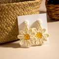 Detailed view of handmade woven raffia sunflower earrings on a rustic woven background - Off-White Sunflower Ear Hook (29359-ear-white-EP)