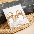 Detail of bohemian gold hoop earrings with white hand-woven cotton thread on a rustic stone - Gold Hoop White Woven Rope (29320-white)