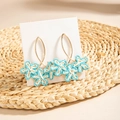 Detail of leaf-shaped raffia earrings with blue and white woven flowers on gold hooks - Blue & White Triple Flower Cluster (29321-blue)