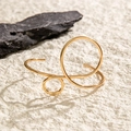 Detailansicht eines minimalistischen goldenen geometrischen Armreifs auf Naturstein - Goldenes Armband (28259-G)