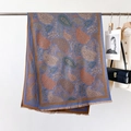 Detailed view of grey-blue paisley pattern scarf with fringes draped in a chic setting - Classic Paisley Blue