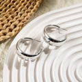 Macro shot of silver chunky hoop earrings with mirror finish on textured white ceramic tray - Chunky C-Shape Mirror Hoops (28578-7-silver)