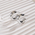 Detail view of silver C-shaped chunky earrings with polished finish on a white tray - High-Precision Polished Mirror C-Shape Earrings (28578-9-silver)