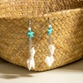 Détail de boucles d'oreilles de plage avec étoiles de mer et coquillages sur un panier tressé - Style de Conque à Franges Étoile de Mer (29337-3)