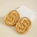 Detailed view of large gold oval earrings with spiral texture on a stone background - Gold Lava Fluid Oval Texture Style (29424-G)