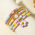 Dettaglio di braccialetti colorati in argilla polimerica con ciondoli a fiori viola - Fiore Viola Macaron Set da 5 pezzi (31161-bra-purple-EP)