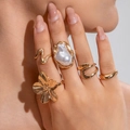Nahaufnahme von Goldblumenring und Barockperlenring aus einem Vintage-Fünfer-Set - Barock Kunst Kunstperlen 5-teiliges Set (29931-G)