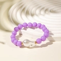 Close-up of purple beaded bracelet with white baroque pearl and golden spacers - Purple