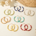 Détail de boucles d'oreilles bohèmes serties de perles en résine colorées et dorées - Ensemble Multicolore