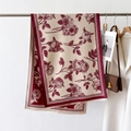 Detail of red rose and houndstooth pattern scarf with fine tassel edges on display - Red