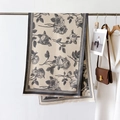 Detail view of beige scarf with black rose patterns, houndstooth edges and fine tassels - Gray