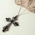 Macro view of gothic hollow cross pendant with black crystals and layered Y-necklace detail - Luxury Rhinestone Black Gem Gun-Black Cross (30728-nek-S-4)