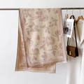 Detail of floral beige scarf with houndstooth borders and fringe on a metal hanger - Khaki Pink
