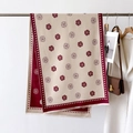 Detail of camellia and polka dot patterned scarf with tassels displayed on a hanger - Red
