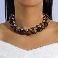 Primo piano di perle stile ambra e sfere argentate su una collana moderna e appariscente - Stile Perline Crackle Marrone Scuro (28353-brown)