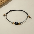 Detail of adjustable black cord bracelet with blue evil eye bead and golden accents - Black Braided Rope (30532-bra-blk-8-EP)