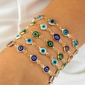 Close-up of stacked gold-plated Evil Eye charm bracelets with colorful resin beads - Stacked Layered (30720-bra-cor-EP)
