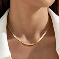 Close-up of golden flat snake chain necklace on model with white blazer suit - Gold Flat Snake Bone Necklace (30633-nek-G)