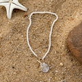 Bohemian pearl necklace featuring a golden shell pendant and toggle clasp on sand - Artificial Pearl Gold Shell Toggle Clasp Necklace (29284-1-G)