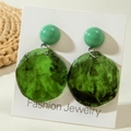 Détail macro de boucles d'oreilles en acrylique avec motif marbré vert et clous polis - Rond Marbré Vert Foncé
