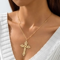 Gros plan d'un collier croix baroque dorée avec des textures gravées complexes sur un mannequin - Collier Pendentif Croix Baroque Sculptée Ajourée (30740-nek-G-4)