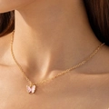 Gros plan d'un collier pendentif papillon rose avec chaîne dorée sur le cou d'un mannequin - Collier Chaîne Fine en Or Papillon Rose (30573-nek-G-EP)