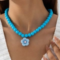 Collier de perles bleues avec pendentif fleur de camélia porté par un mannequin en douceur - Collier à Perles Fleur (29959-nek-blue-A-EP)